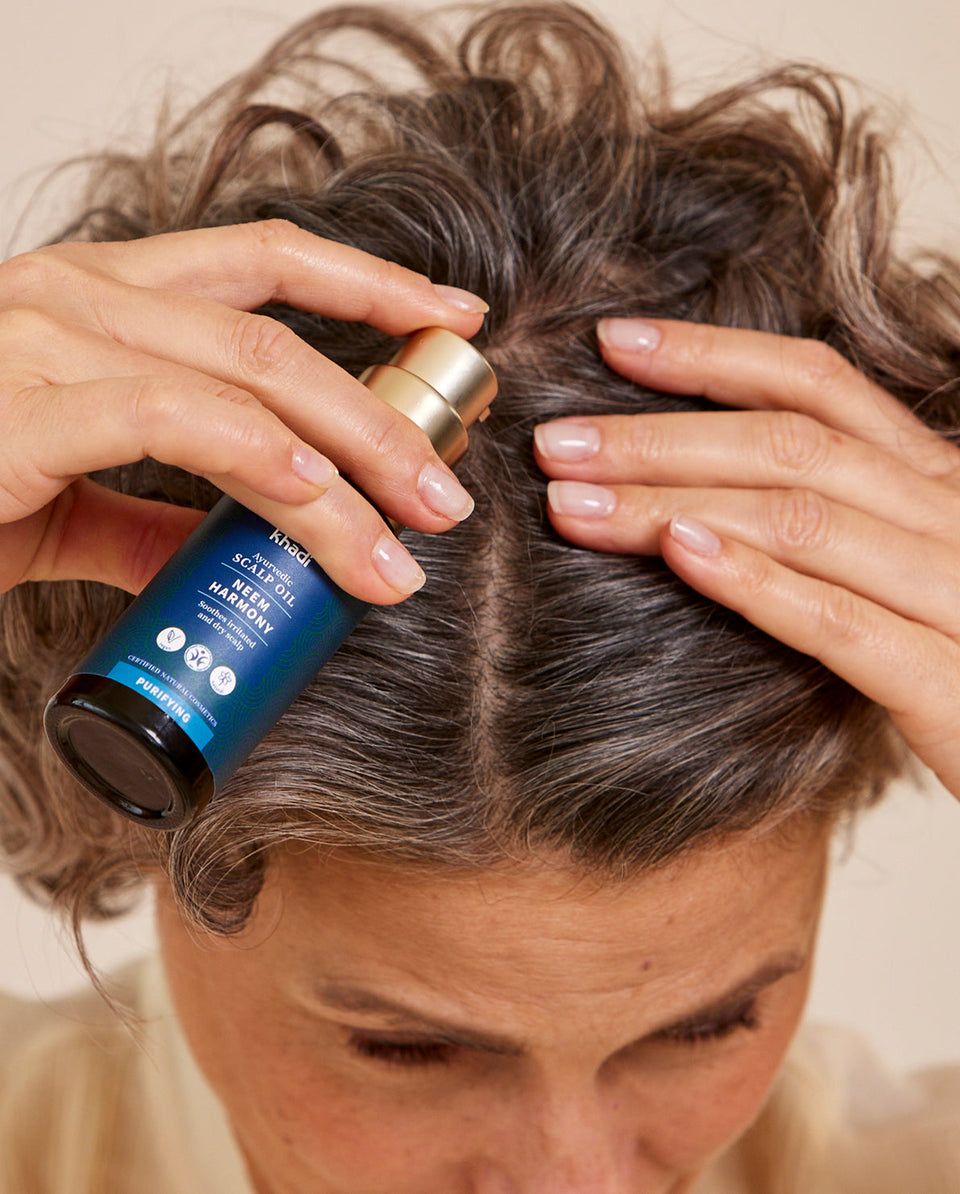 Immagine dell'applicazione dell'olio per capelli al Neem, modello a mano di khadi